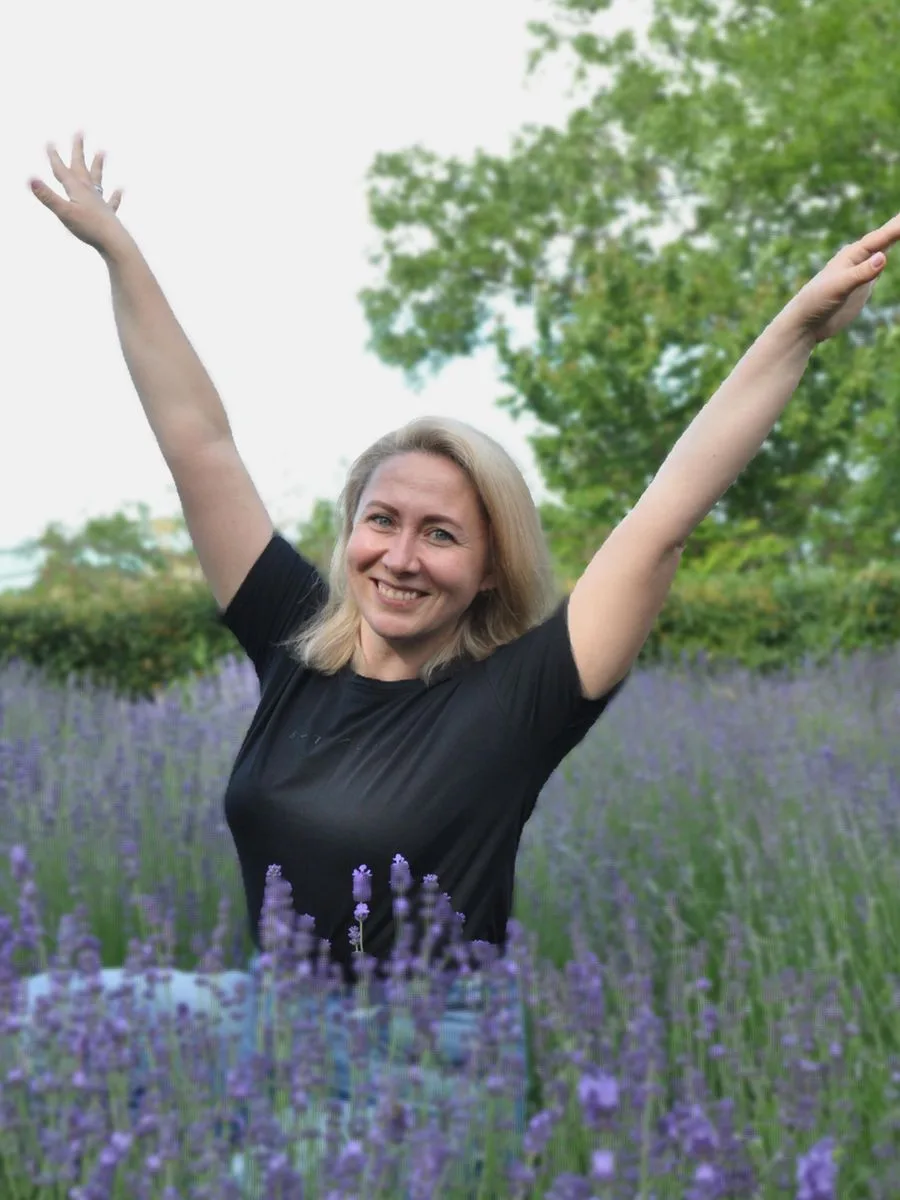 Woman with arms raised enjoying a lavender field
